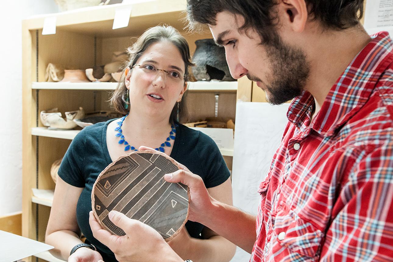 Two students examining pottery