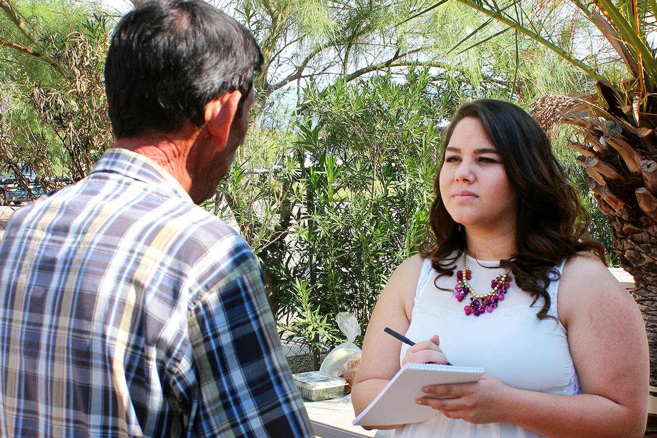 Female student interviewing man outdoors